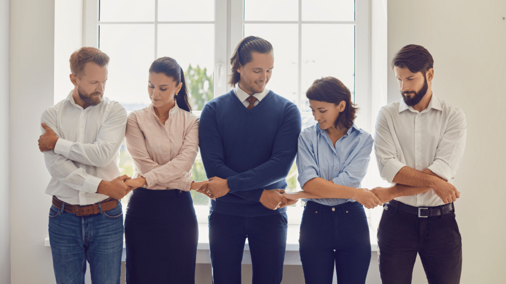 Employees standing in a row holding hands