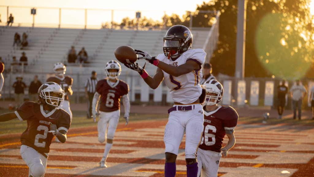 man catching brown football