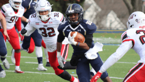 football player carrying brown football